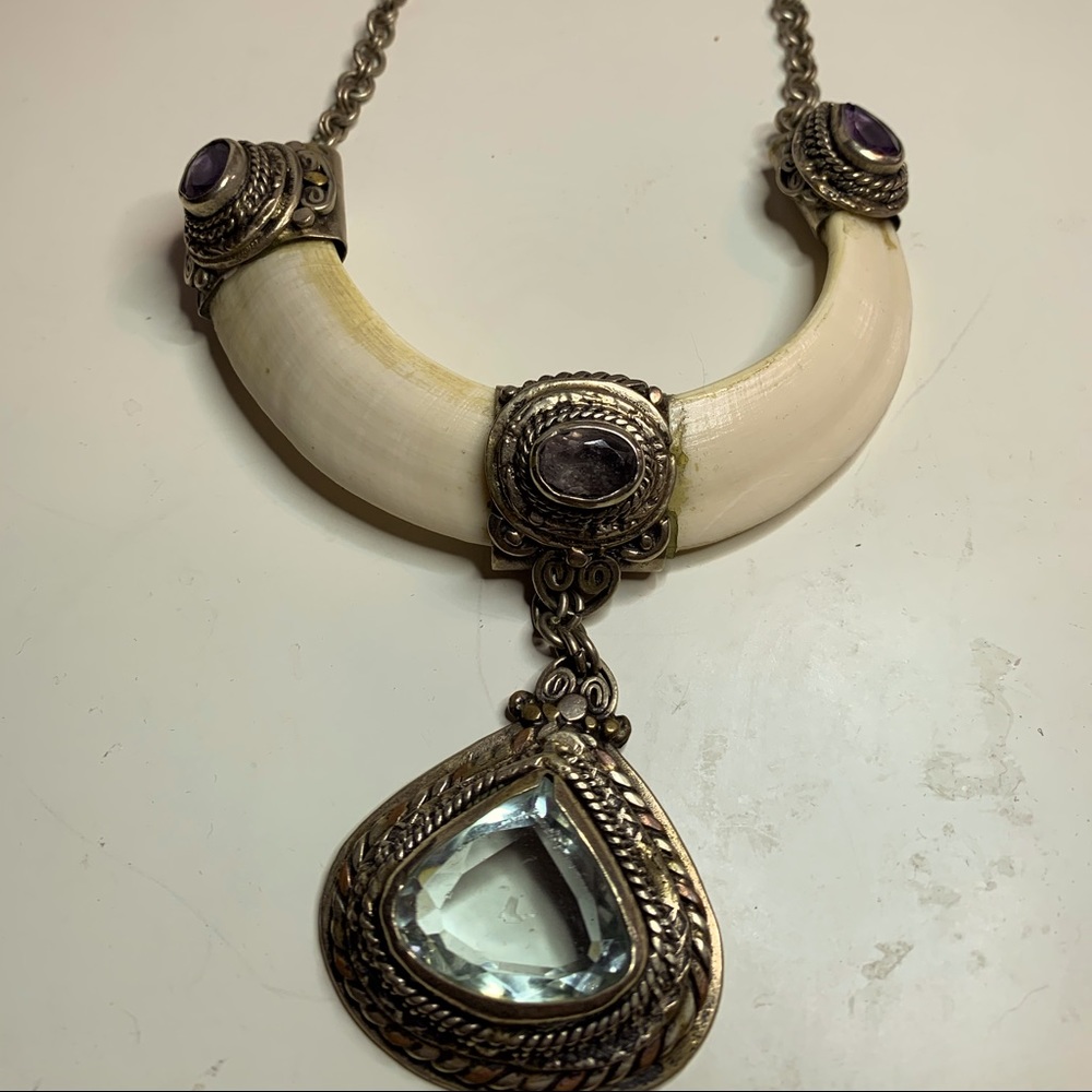 Boars tusk with metal and stones necklace.